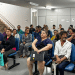 Pessoas aguardam atendimento sentadas em sala de espera de agência do INSS, perto do setor de perícia médica.