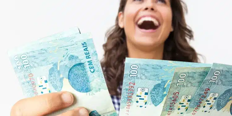 Mulher sorrindo segura notas de R$ 100 ao representar pagamento de R$ 1.486 ou mais para brasileiros com CPF de finais de 0 a 9.
