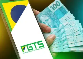Celular exibindo logotipo do FGTS ao lado de mão segurando leque de notas de cem reais