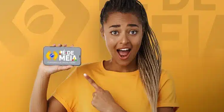 Estudante sorridente apontando para celular com a logo do Pé-de-Meia na tela em fundo amarelo, representando o pagamento do programa pelo Caixa Tem