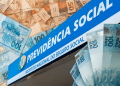 Fachada azul do INSS com logo oficial rodeada por notas de 50 e 100 reais brasileiros espalhadas, simbolizando os pagamentos do INSS no mês de maio.