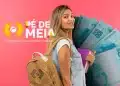 Estudante com mochila e arte do Pé-de-Meia ao lado, programa de poupança do ensino médio, com cédulas de dinheiro ao fundo, representando os pagamentos de maio.