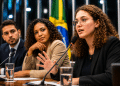 Três pessoas participam de uma mesa de debate com microfones em uma sessão no Congresso