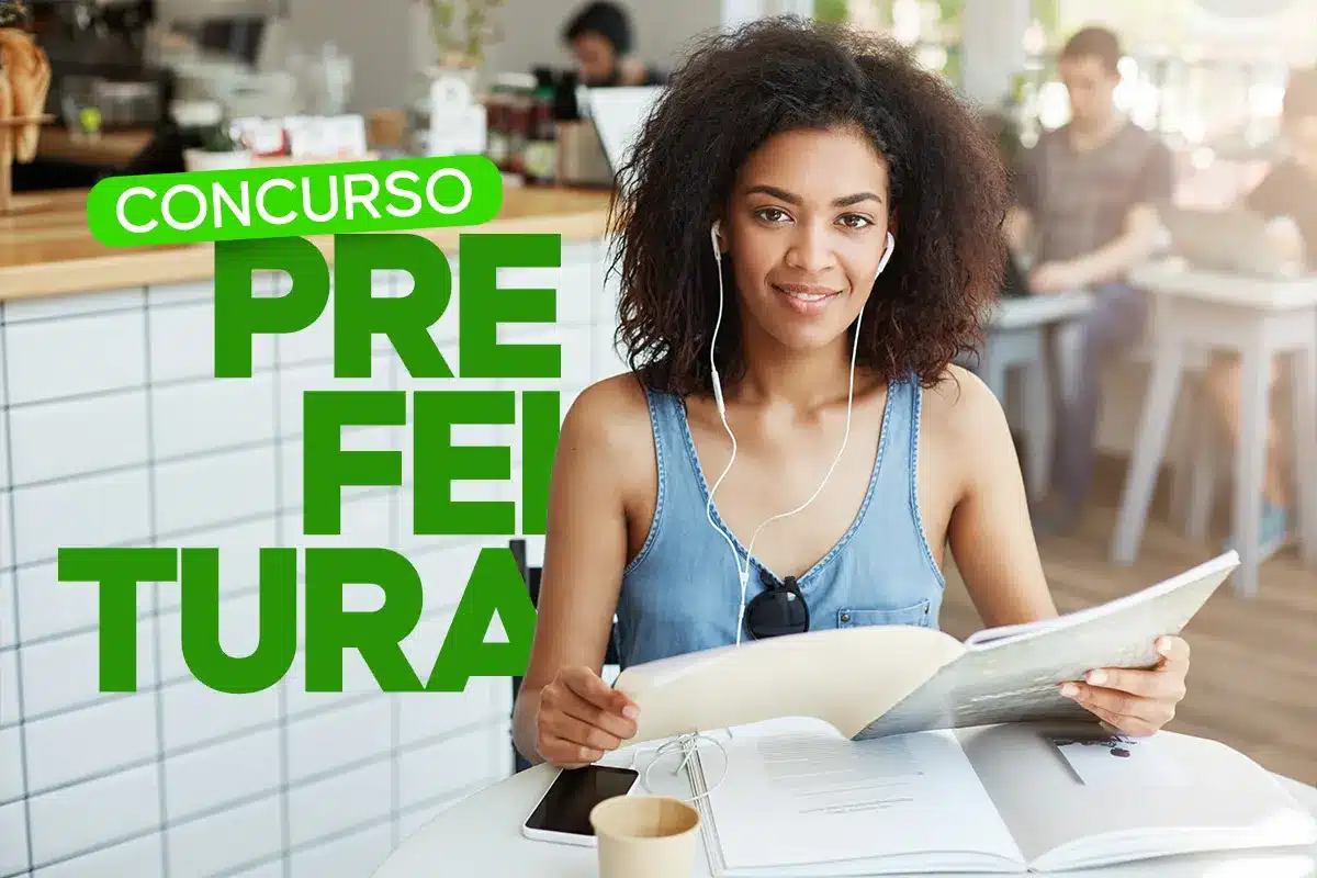 Mulher jovem com fones de ouvido segurando livro de estudo em ambiente de café com outras pessoas ao fundo