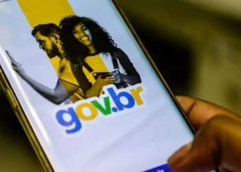 Mão segura um celular com a tela do aplicativo Gov.br