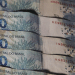 Cédulas de R$ 100 do Banco Central do Brasil empilhadas, representando o saque de até R$ 6.220 liberado pela Caixa com prazo final em 19 de maio de 2026.
