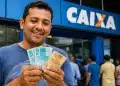 Homem sorrindo, segurando notas de real em frente à Caixa, representando o saque de R$ 1.028,01 liberado para CPFs com finais de 0 a 9.