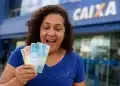 Mulher feliz segurando notas de dinheiro em frente a uma agência da CAIXA, destacando saque de R$ 6.220 disponível até 30 de maio.
