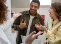 Três jovens conversando animadamente em ambiente descontraído com gestos expressivos