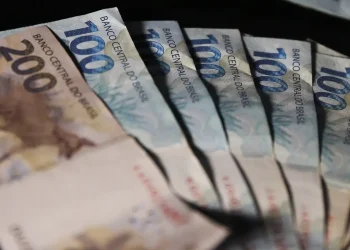 Cédulas de duzentos e cem reais em destaque representando o pagamento do 13º salário dos aposentados e pensionistas do INSS