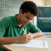 Estudante de camiseta verde preenche ficha em sala de aula, em preparação para a Olimpíada Nacional de Eficiência Energética 2026.
