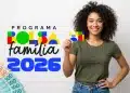 Mulher segurando cartão do Bolsa Família 2026 ao lado de cédulas de real, representando os valores pagos pelo programa.