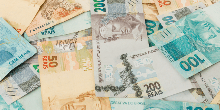 Notas de real brasileiro em diversas denominações espalhadas.