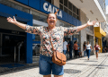 Mulher comemora em frente à Caixa Econômica após benefício liberado.