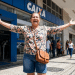Mulher comemora em frente à Caixa Econômica após benefício liberado.