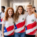 Estudantes do Ensino Médio posam em corredor escolar com uniforme estadual.