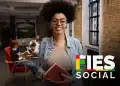 Estudante segurando caderno em ambiente acadêmico com logo do Fies Social, em referência ao edital de adesão do Fies 2026.