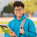 Jovem sorrindo com cadernos em campus universitário ao ar livre.