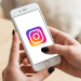 Pessoa com unhas pretas acessa o Instagram no smartphone.