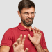 Homem expressando nojo em destaque com camisa vermelha.