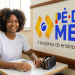 Estudante do ensino médio em sala de aula ao lado da logo do Pé-de-Meia.