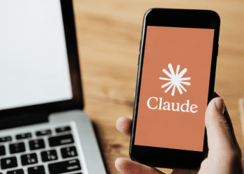 Logo do Claude exibido em smartphone ao lado de notebook.