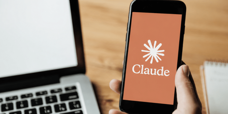 Logo do Claude exibido em smartphone ao lado de notebook.