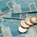 Notas de cem reais e moedas de um real.
