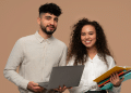 Professores sorridentes com laptop e cadernos sobre fundo bege.