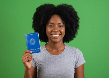 Jovem negra exibe carteira de trabalho e previdência social.