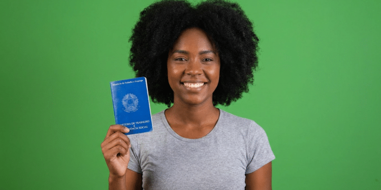 Jovem negra exibe carteira de trabalho e previdência social.