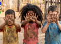 Crianças exibindo mãos sujas, remetendo ao trabalho infantil.