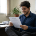 Homem sorri ao ler um contrato de trabalho em escritório