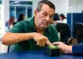 Segurado do INSS realiza cadastro de biometria em scanner digital durante atendimento, representando as novas regras para o cadastramento biométrico.