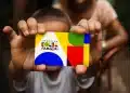Criança segurando cartão do Bolsa Família durante pagamento do benefício social.