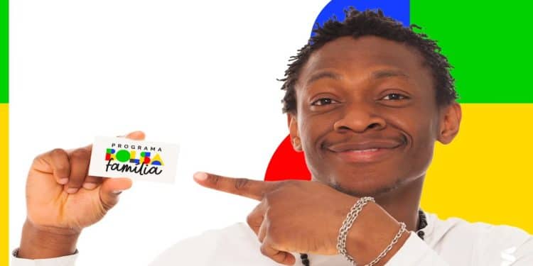 Homem sorrindo segura e aponta para um cartão do Programa Bolsa Família, em referência ao pagamento de junho de 2026, que pode chegar a R$ 1.000 conforme a composição da família