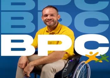 Homem sorridente em cadeira de rodas ao lado da sigla BPC, representando o pagamento do benefício em junho.