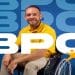 Homem sorridente em cadeira de rodas ao lado da sigla BPC, representando o pagamento do benefício em junho.