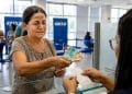 Mulher saca notas de R$ 100 e R$ 50 no caixa de uma agência da Caixa, em imagem que ilustra os pagamentos do Bolsa Família de junho, iniciados no dia 17 e mantidos até o dia 30