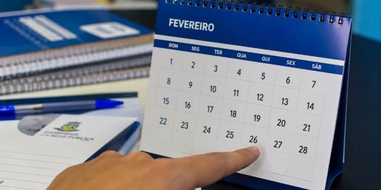 Pessoa aponta para um calendário de mesa de fevereiro que termina no dia 28, sem o dia 29 do ano bissexto