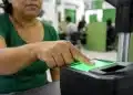 Pessoa realizando coleta de impressão digital em estação de biometria para emissão da nova Carteira de Identidade.