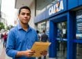 Jovem segura envelope com documentos em frente a uma agência da Caixa, em referência ao novo concurso para técnico bancário
