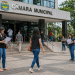 Pessoas em frente à Câmara Municipal lendo documentos de concurso público durante o período de inscrições abertas.