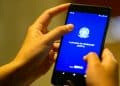 Mãos segurando um celular com o aplicativo Carteira de Trabalho Digital aberto, ferramenta usada para consultar o Abono Salarial do PIS/Pasep em 2026