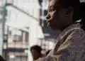 Mulher negra em ambiente urbano ilustra desigualdades no acesso ao emprego.