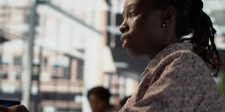 Mulher negra em ambiente urbano ilustra desigualdades no acesso ao emprego.