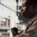 Mulher negra em ambiente urbano ilustra desigualdades no acesso ao emprego.