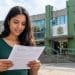 Mulher lê documento em frente a prédio público, representando as inscrições abertas do concurso da Câmara de Mauá