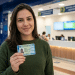Mulher exibe a nova Carteira de Identidade Nacional representando a emissão do documento durante o mutirão do novo RG em Campo Grande
