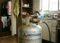 Botijão de gás de cozinha conectado em cozinha residencial com uso diário.